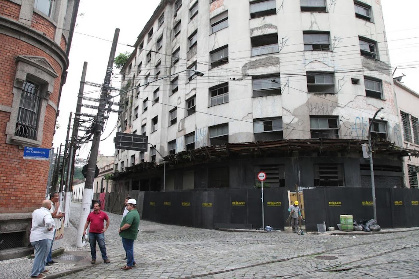 vista geral do prédio com tapume pelo térreo. Homens trabalhando na entrada. #paratodosverem