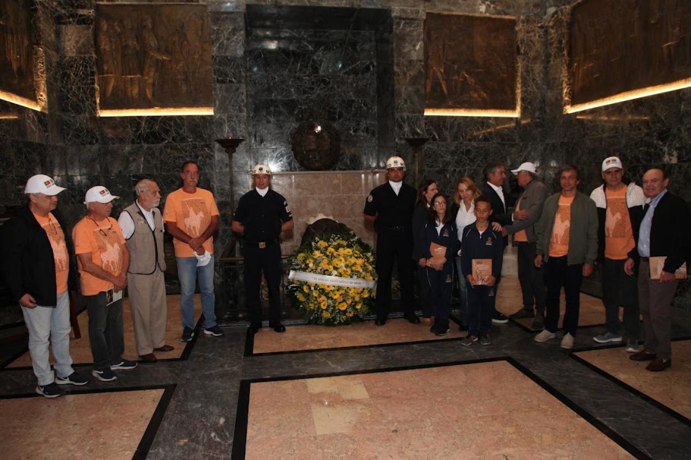 comitiva e autoridades posam com coroa de flores #paratodosverem