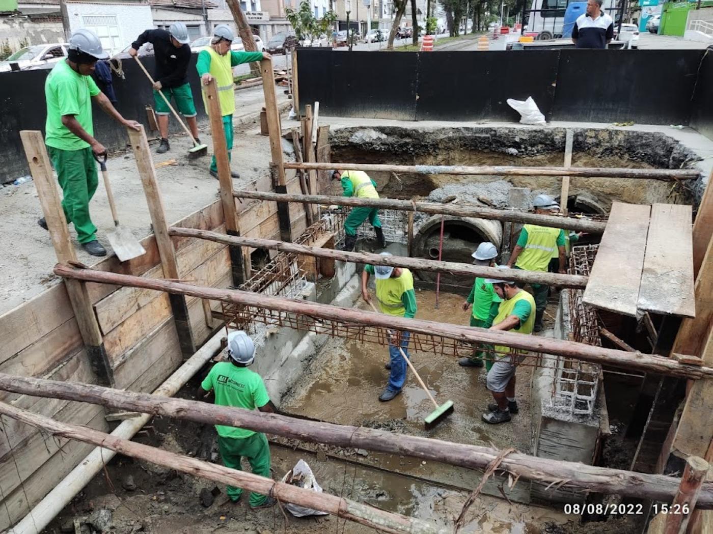 trabalhadores em buraco onde é realizada obra #paratodosverem