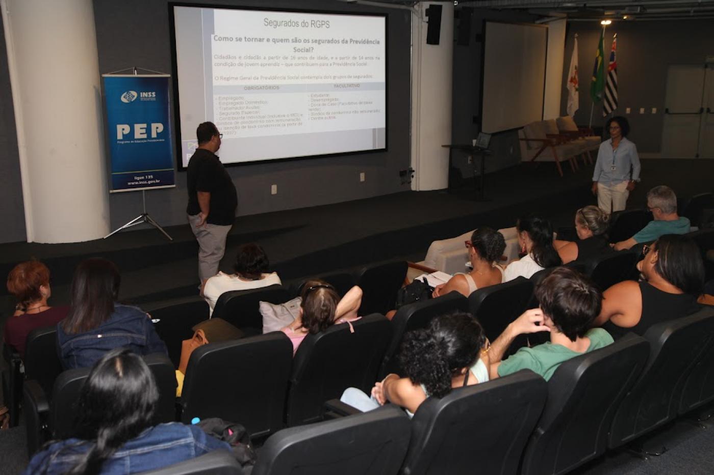 palestra em auditório com pessoas sentadas em um telão à frente. #paratodosverm