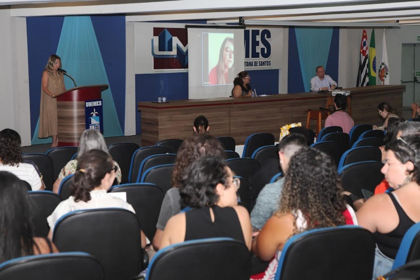 pessoas sentadas em auditório assistindo palestra. #paratodosverem 