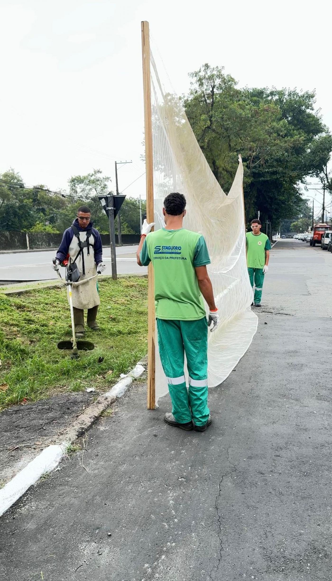 operários atuando no corte de grama #paratodosverem 