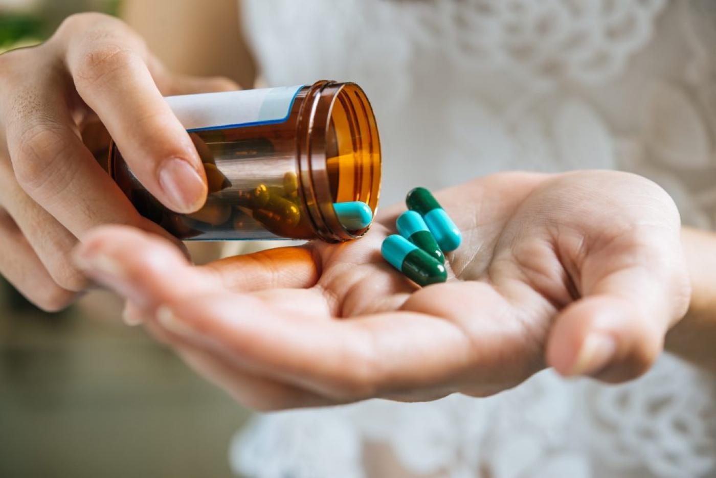pessoa coloca capsulas do remédio na mão #paratodosverem