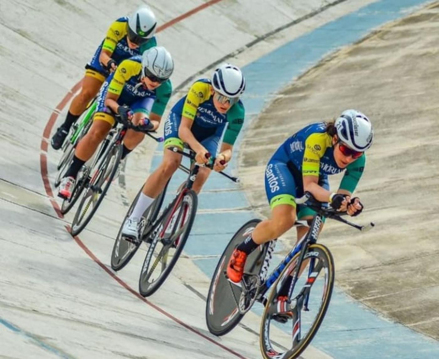 Atletas em cima da bicicleta pedalando em pista #paratodosverem