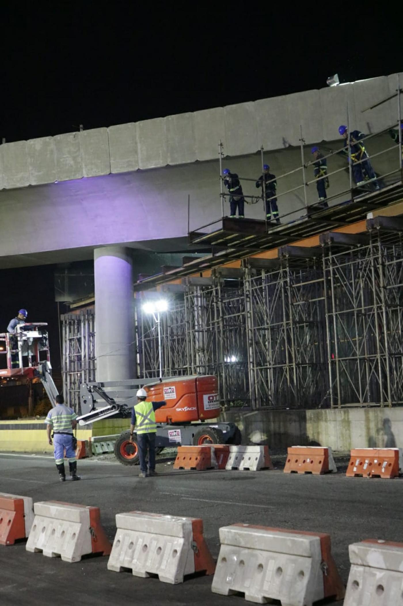 Operários estão sobre andaimes removendo estrutura. Agentes da CET estão na pista. #Paratodosverem