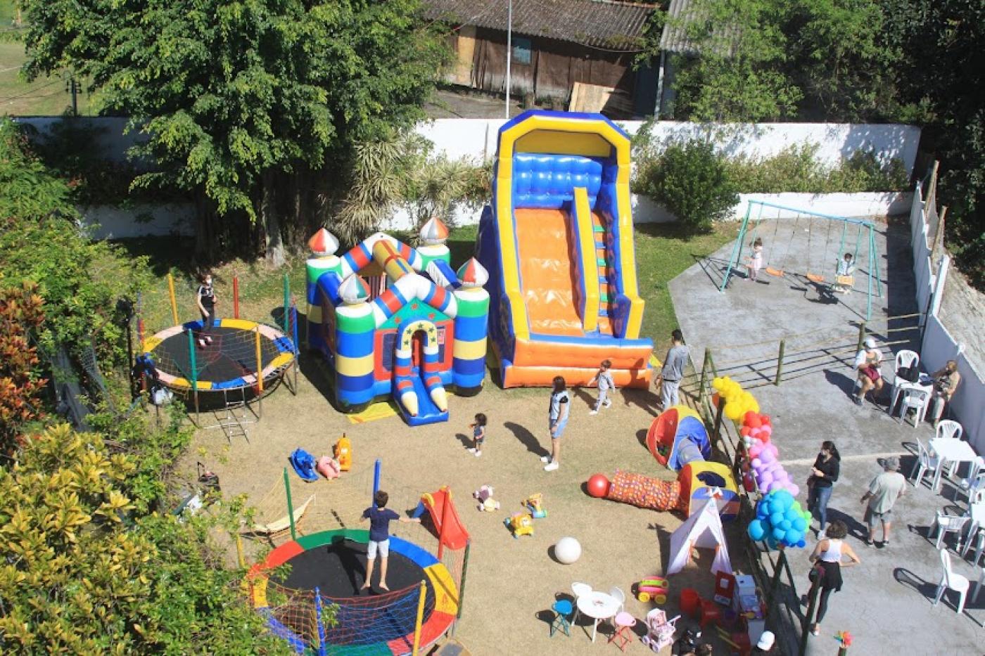 Playgrond com vários brinquedos e crianças brincando. #paratodosverem