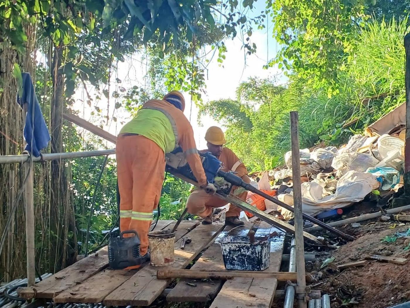 operários atuando na encosta #paratodosverem