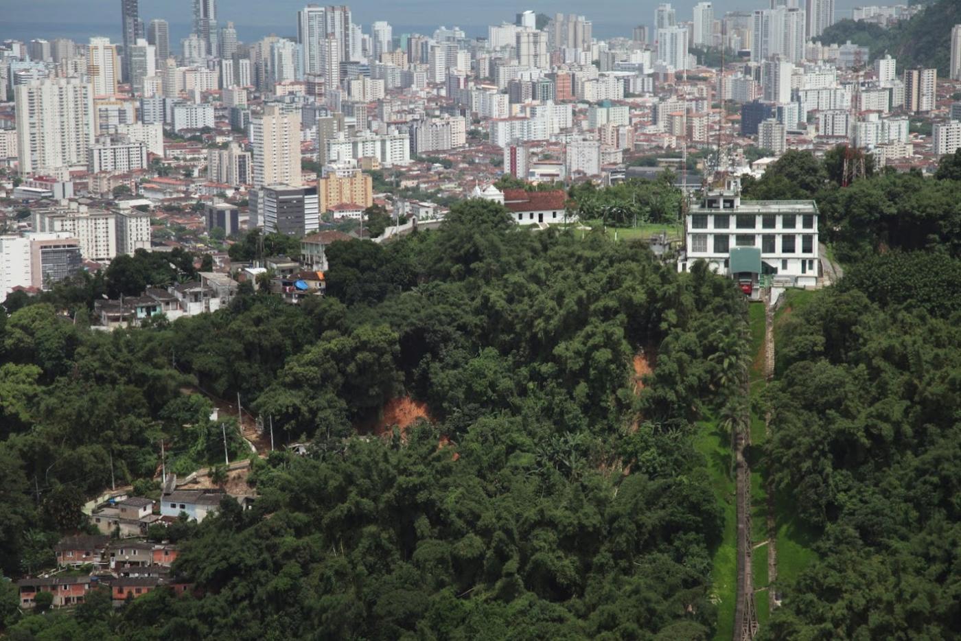 Vista geral de morro com prédios ao fundo. #Paratodosverem