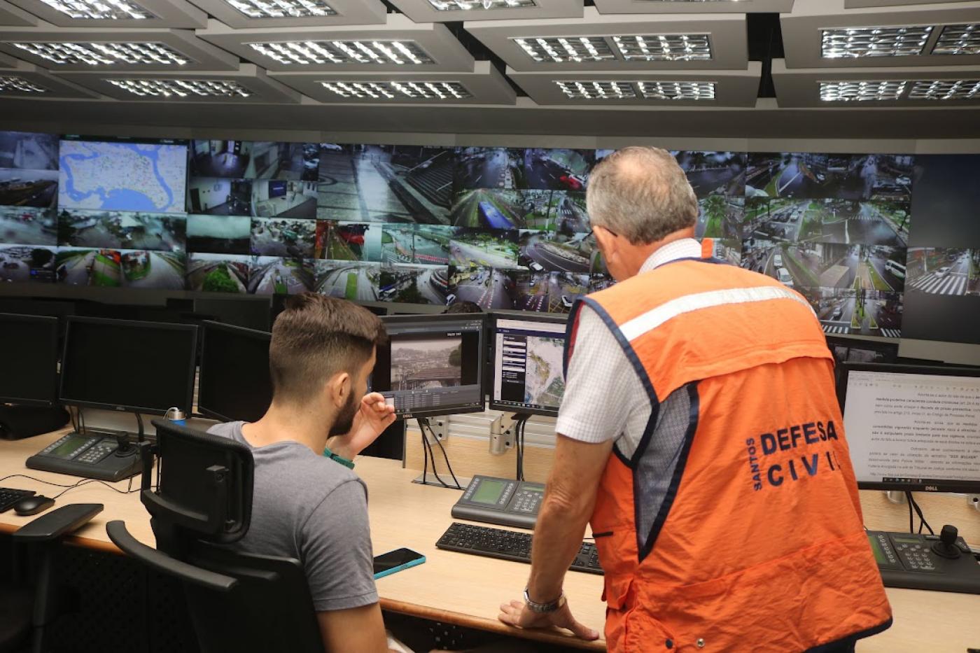 Técnicos da Defesa Civil atuando no centro de câmeras #paratodosverem 