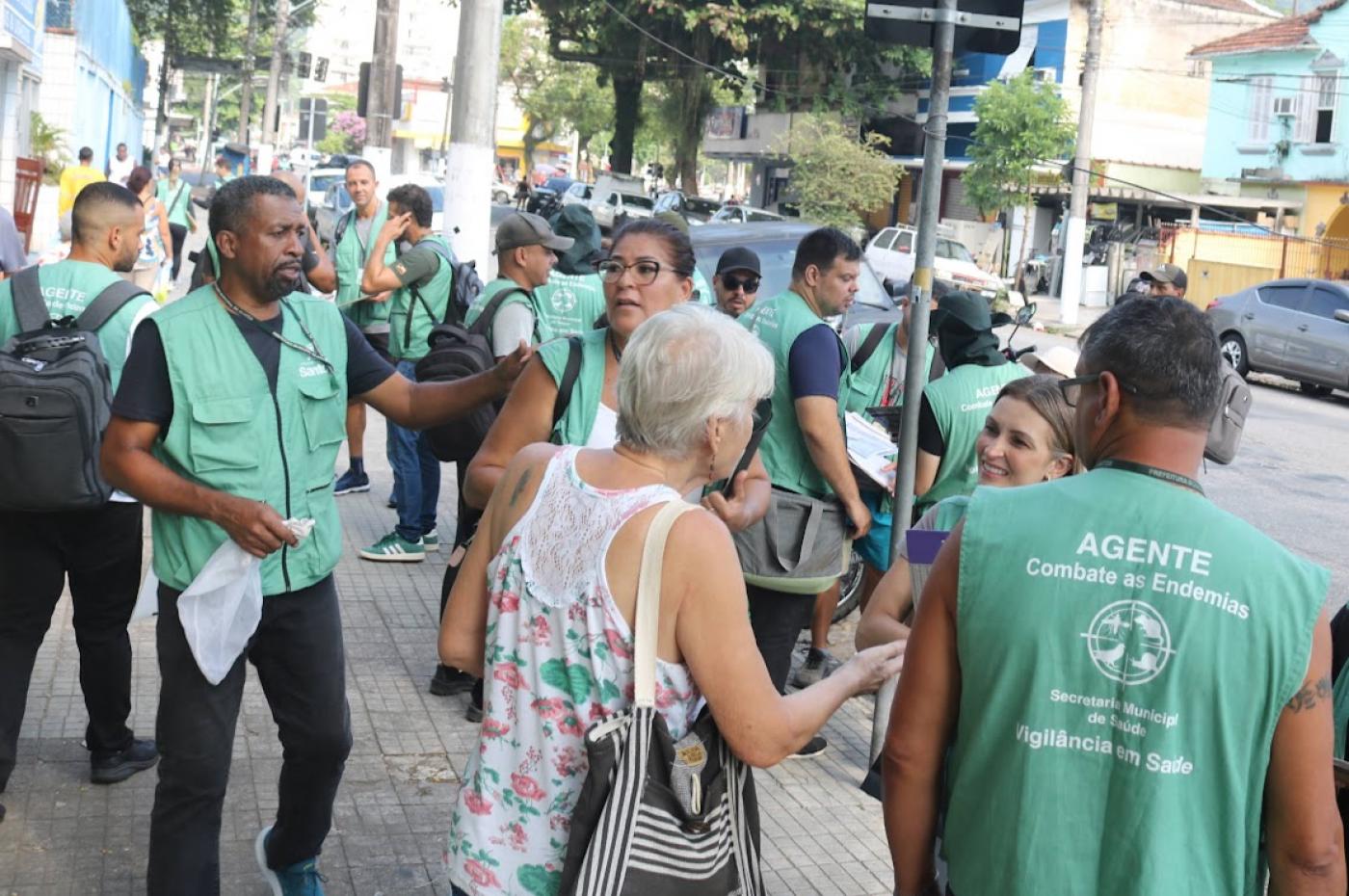 pessoas em contato com agentes na rua #paratodosverem