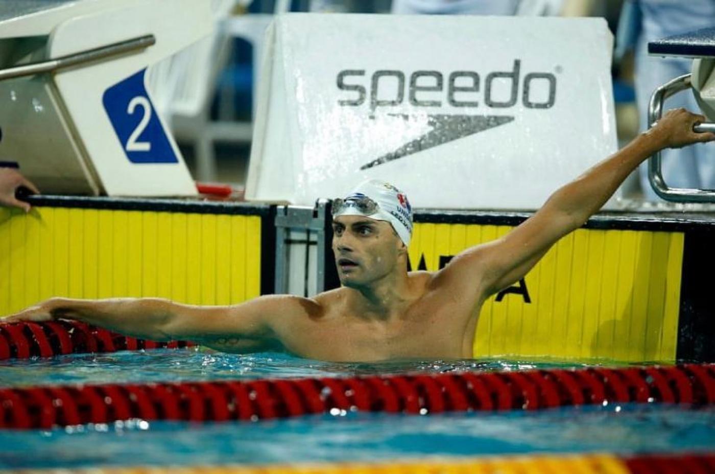 Leonardo de Deus está na piscina, em pé, com o peito e os braços para fora. #paratodosverem