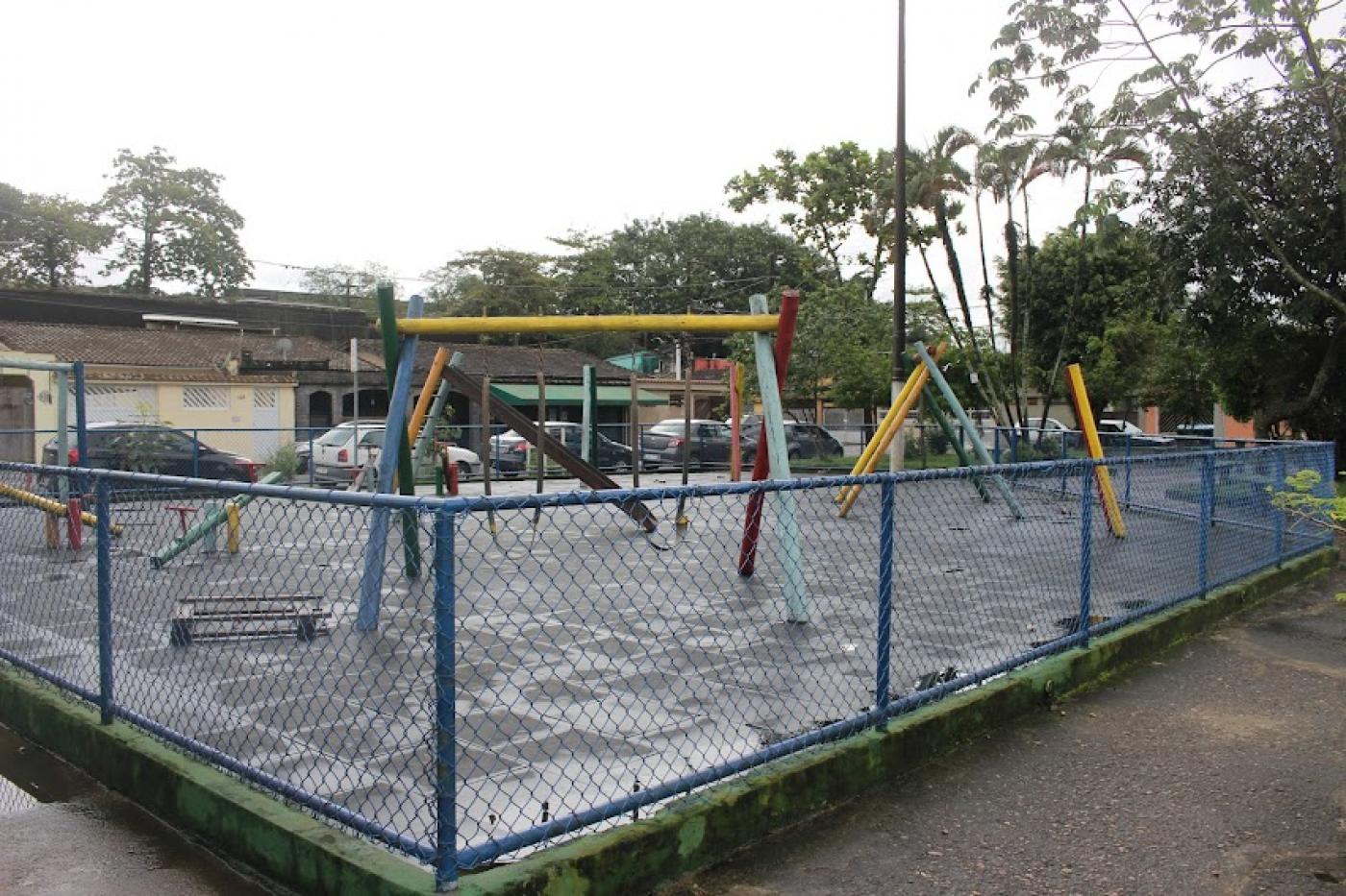 play ground com cerca e vegetação ao fundo. #paratodosverem