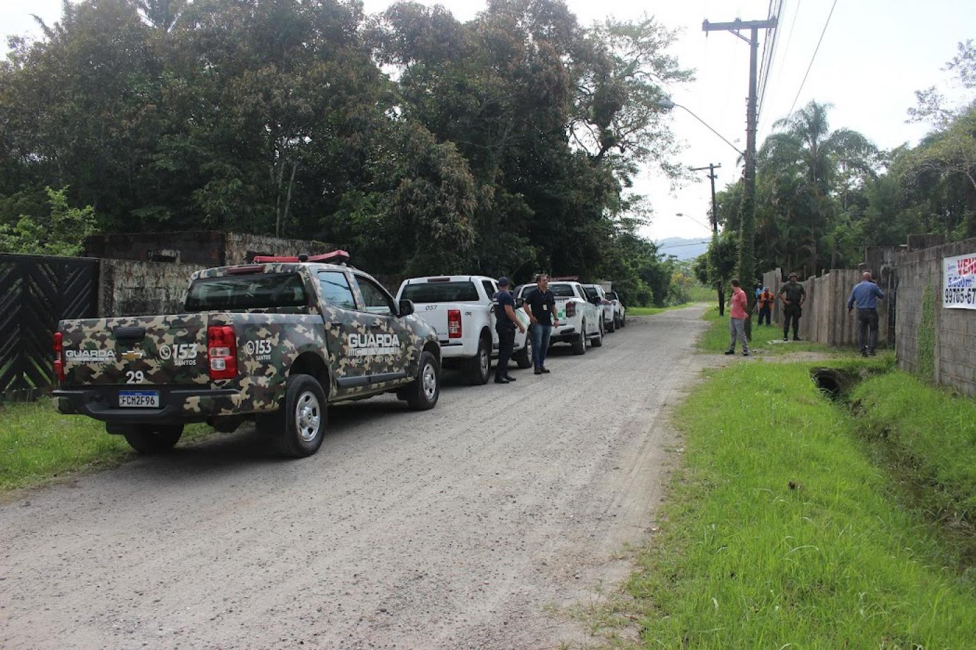 carros e caminhonetes estão em rua de pedra. #paratodosverem