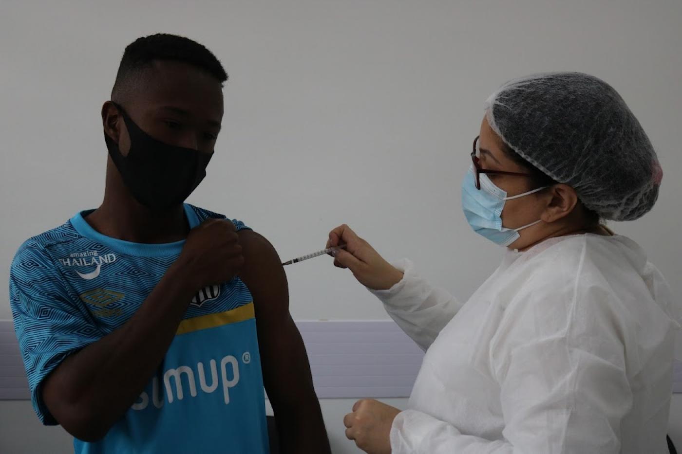 Jovem recebe aplicação da vacina #paratodosverem