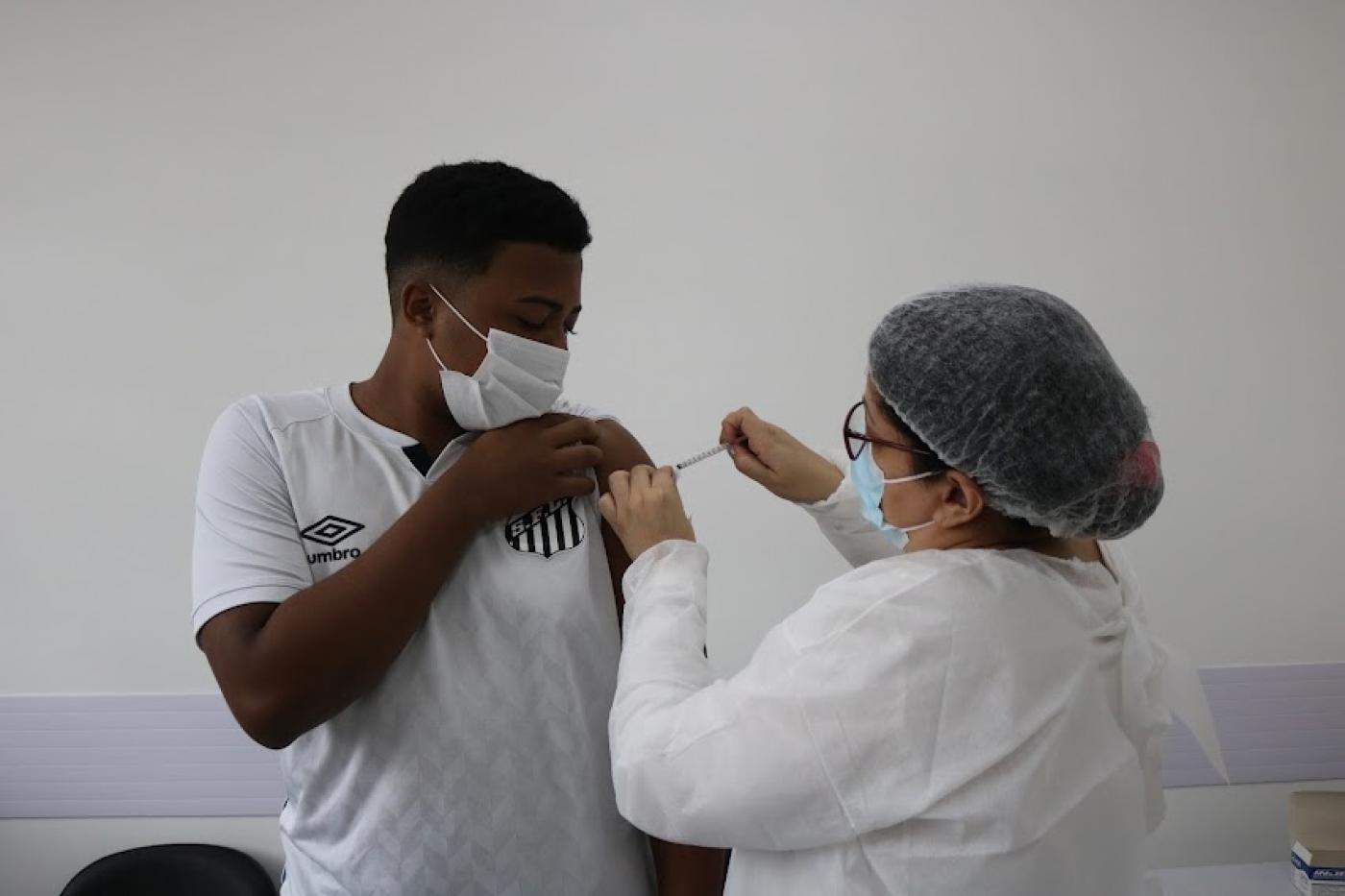 Jovem recebe vacina de enfermeira #paratodosverem