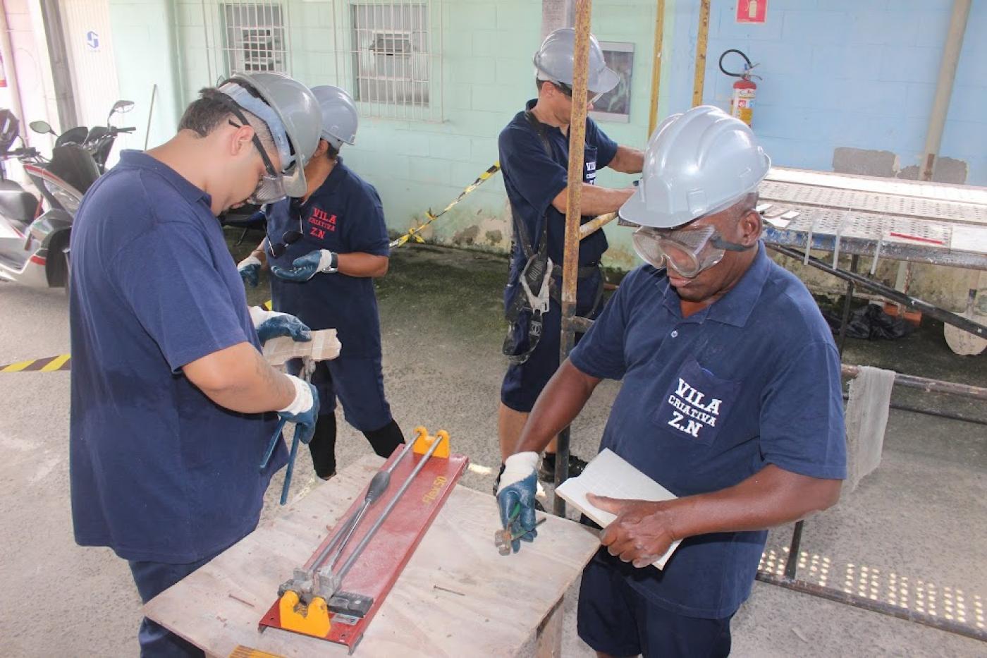 homes estão mexendo em máquina de corte de azulejo. #paratodosverem 