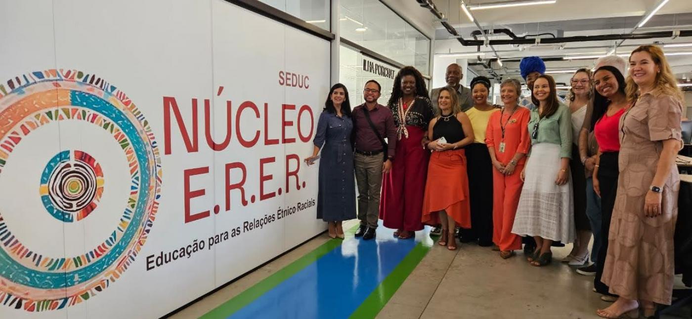 pessoas posam na frente da entrada do núcleo #paratodosverem