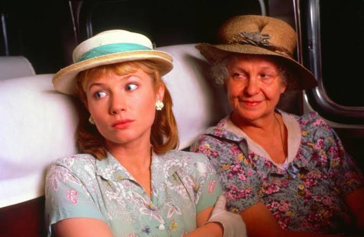 duas mulheres sentadas em cena de filme #paratodosverem