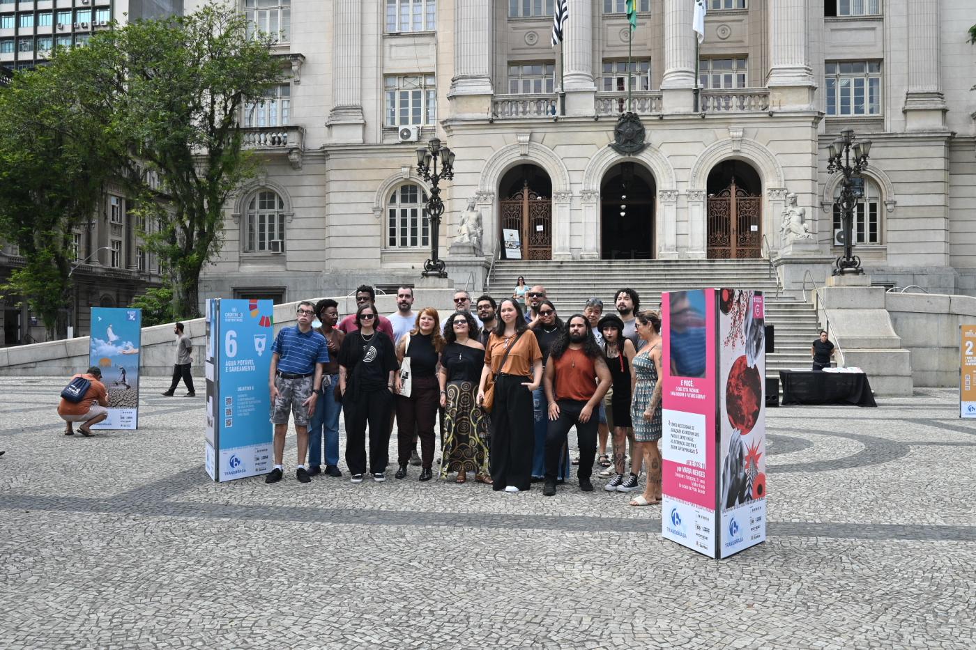 artistas reunidos na praça, na frente de exposição #paratodosverem