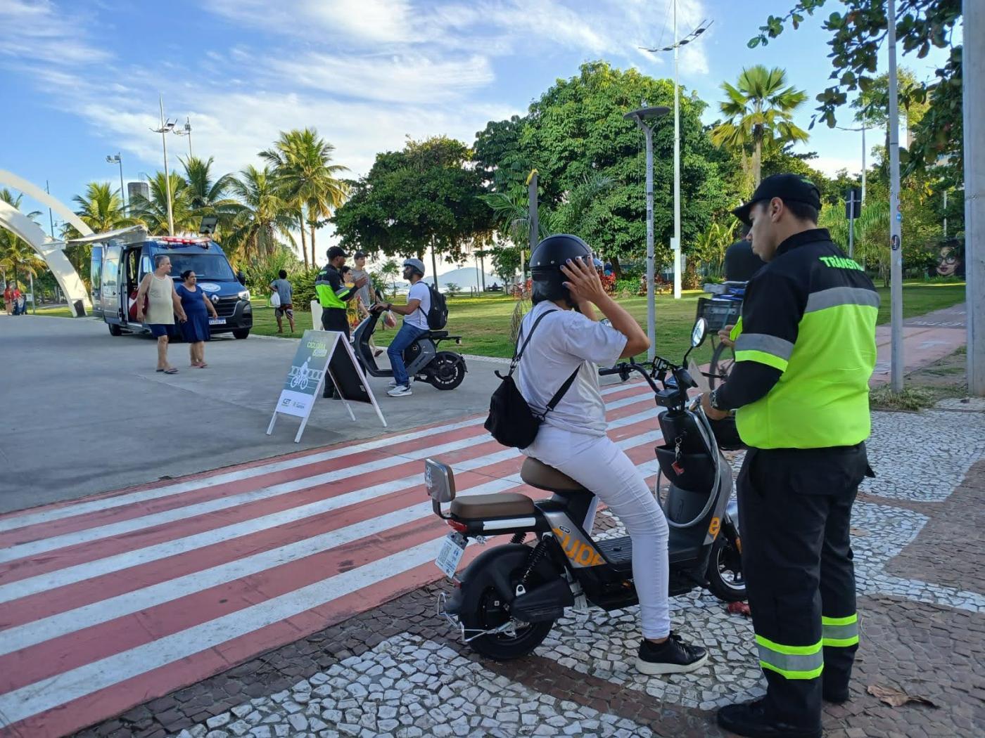 agente da cet conversa com mulher que conduz bicicleta elétrica. #paratodosverem