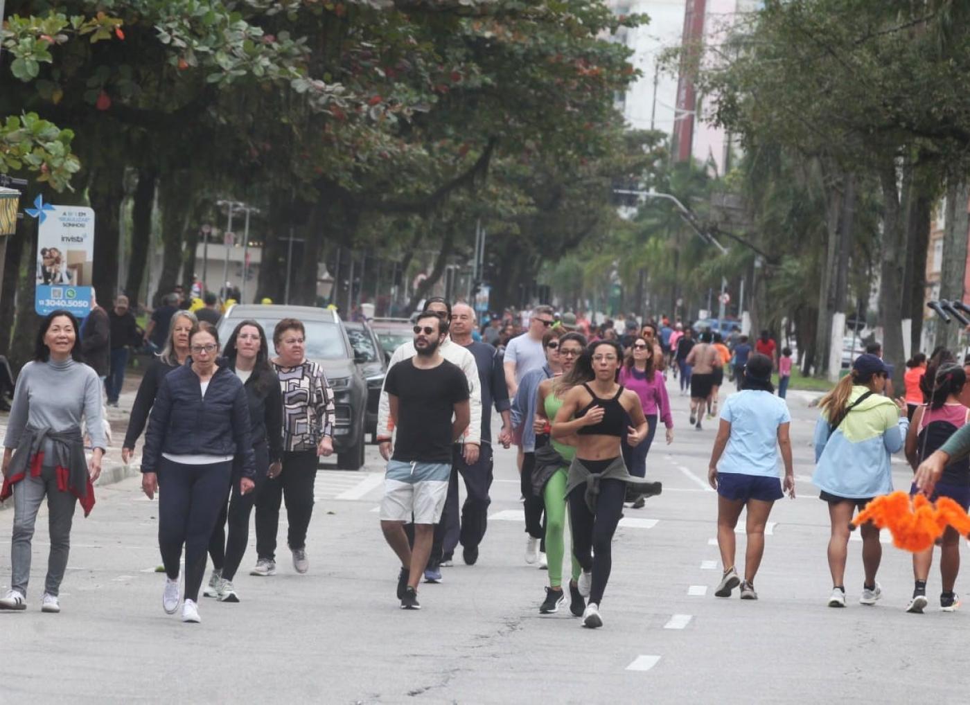 pessoas caminhando e correndo na praia #paratodosverem 