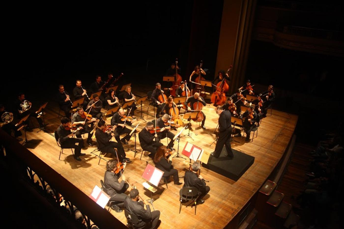 orquestra se apresentando em cima de palco #paratodosverem