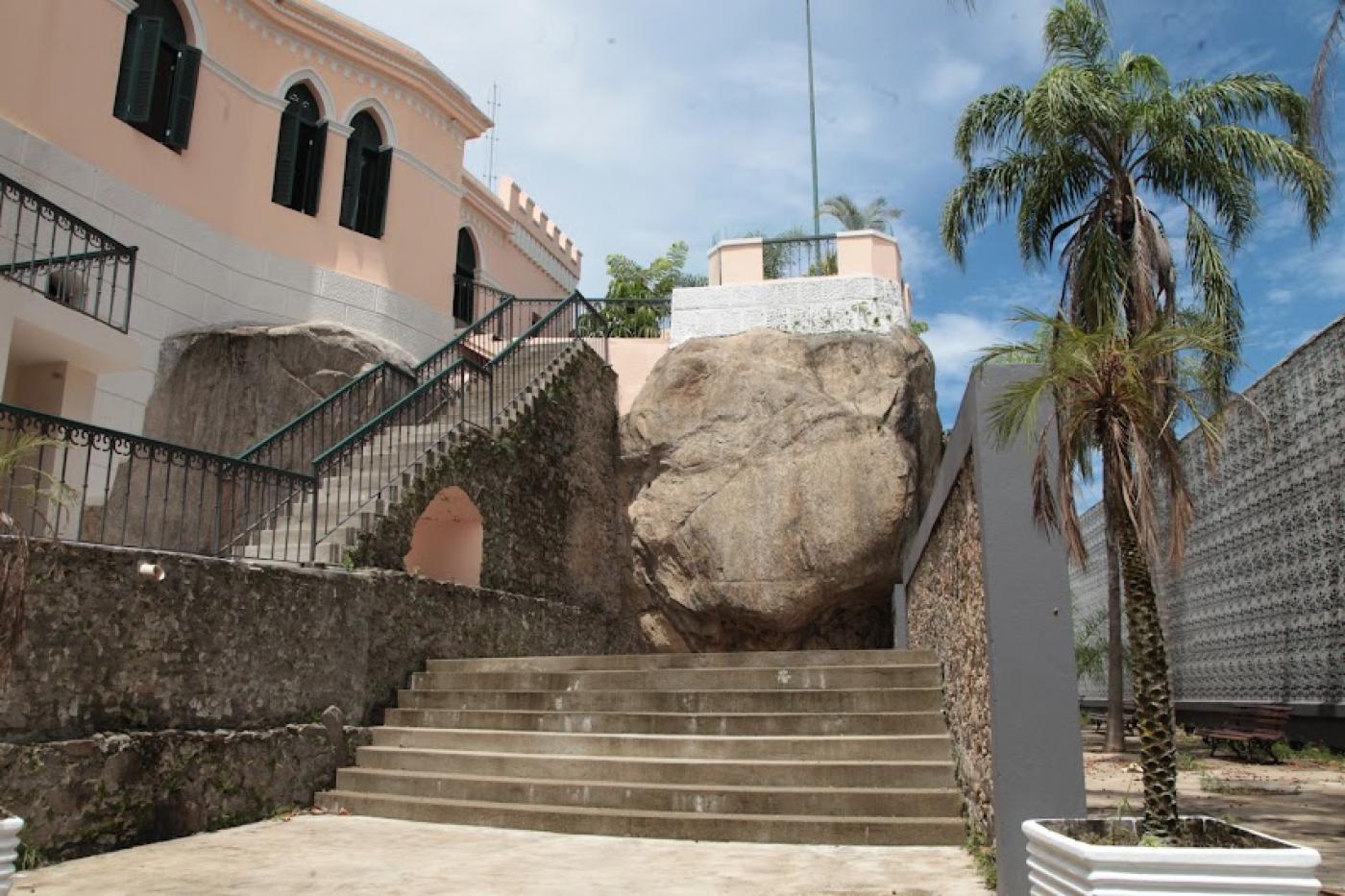 o outeiro de santa catarina, com escada de acesso em primeiro plano. Grande pedra ao fundo e construção à esquerda. #paratodosverem