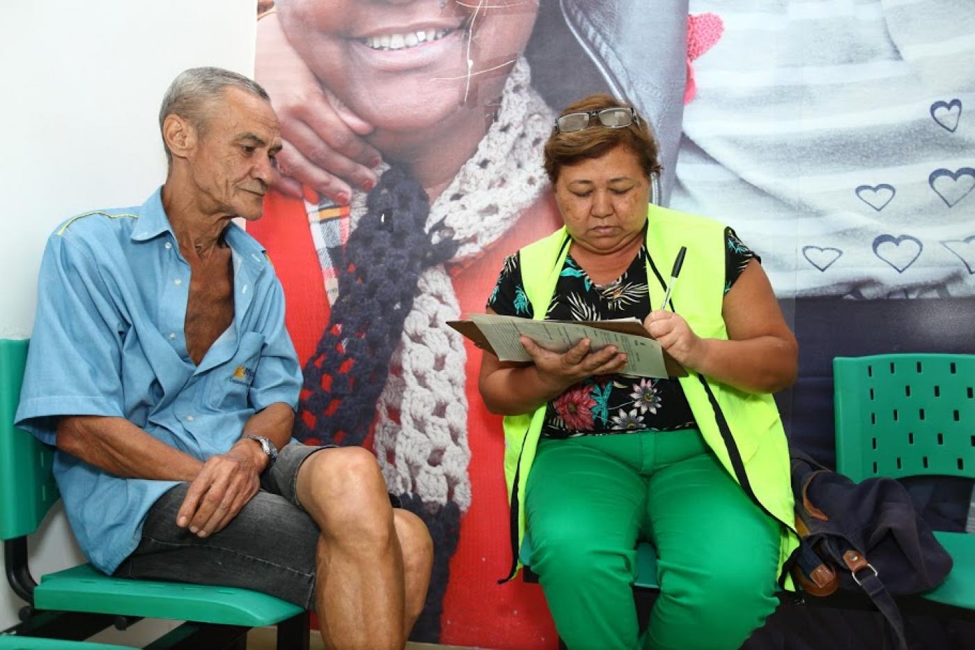 Homem, sentado, é entrevistado por funcionária da Ouvidoria. #pracegover