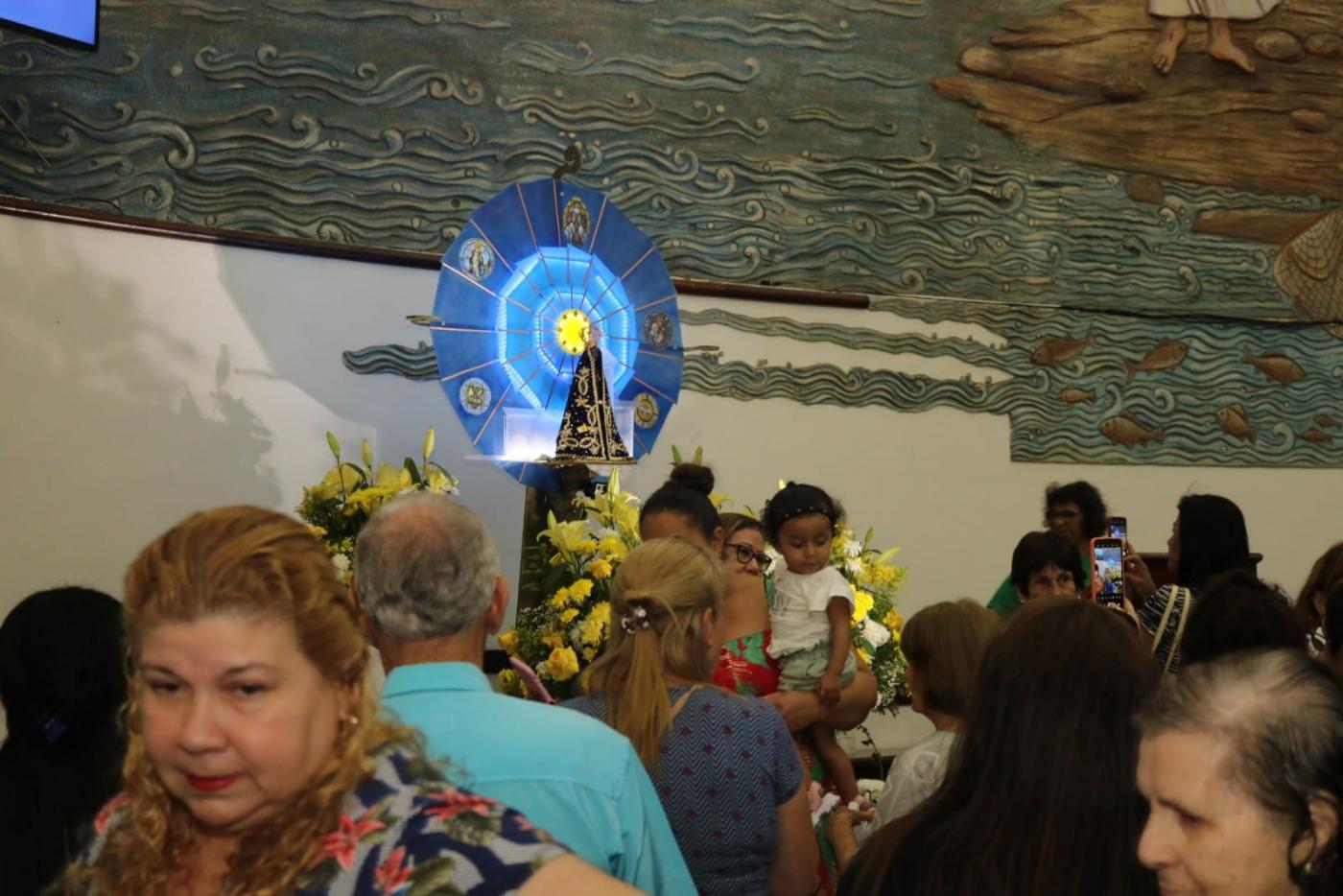 Igreja lotada de fiéis para ver a imagem da Santa. #paratodosverem