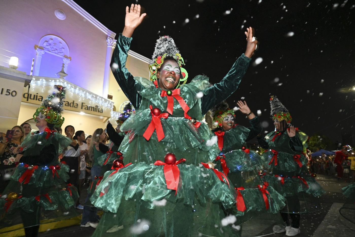mulher desfila fantasiada de árvore de natal e acena para o público. #paratodos