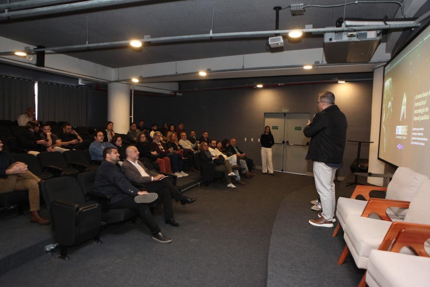Pessoas no auditório acompanhando o evento #paratodosverem 