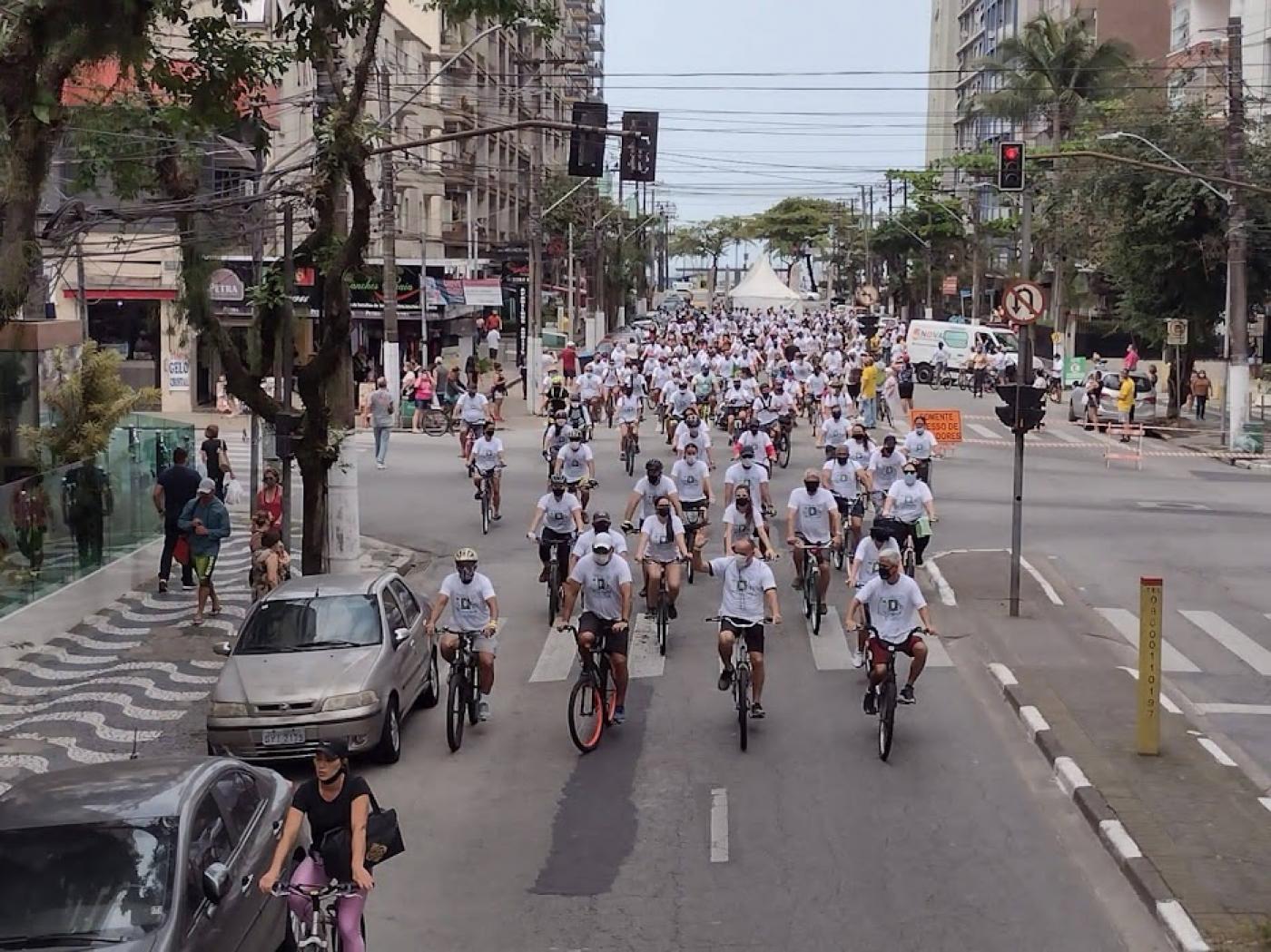 Dezenas de ciclistas e bicicletas passam por avenida. #paratodosverem