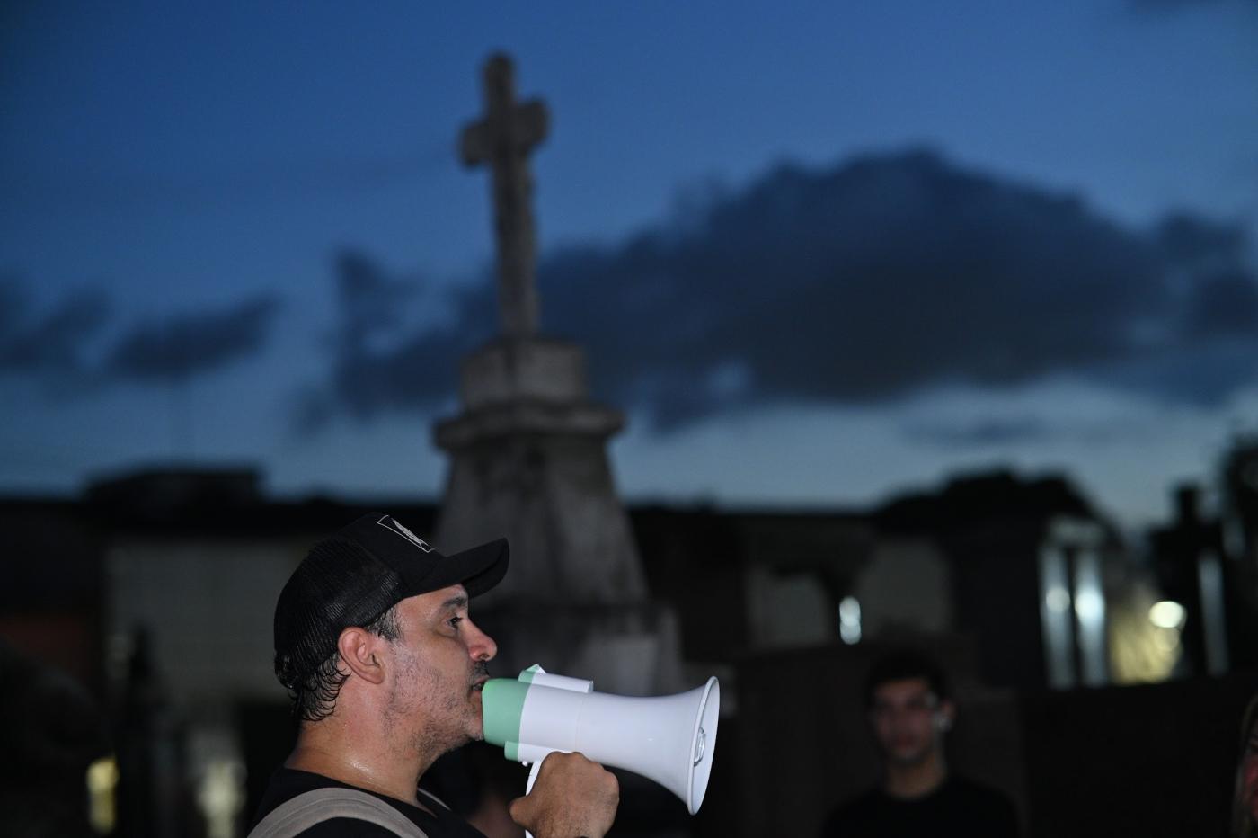 homem com megafone em cemitério à noite. #paratodosverem