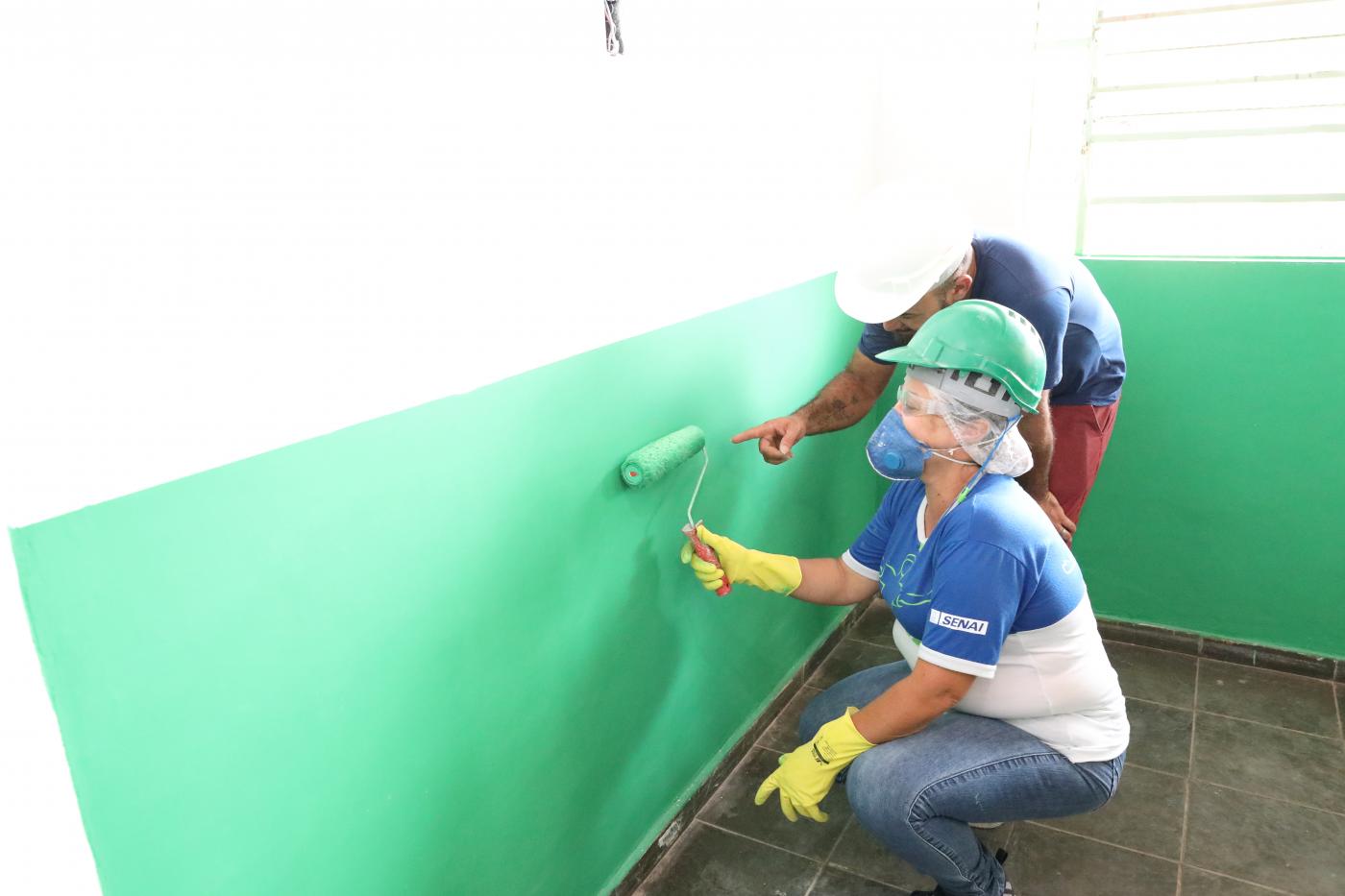 mulher pinta parede observada por professor #paratodosverem 