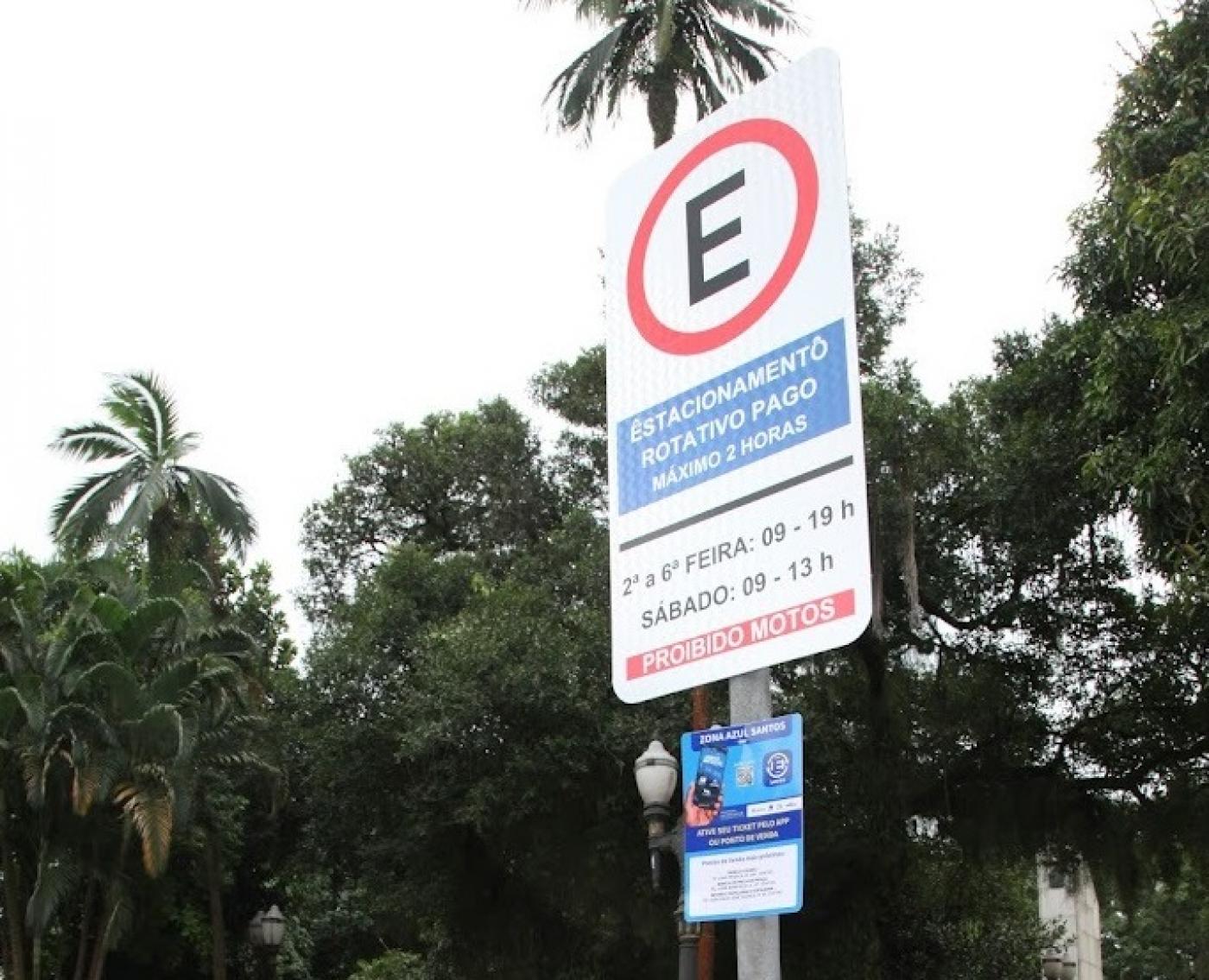 placa de estacionamento regulamentado em primeiro plano. Árvores ao fundo. #paratodosverem