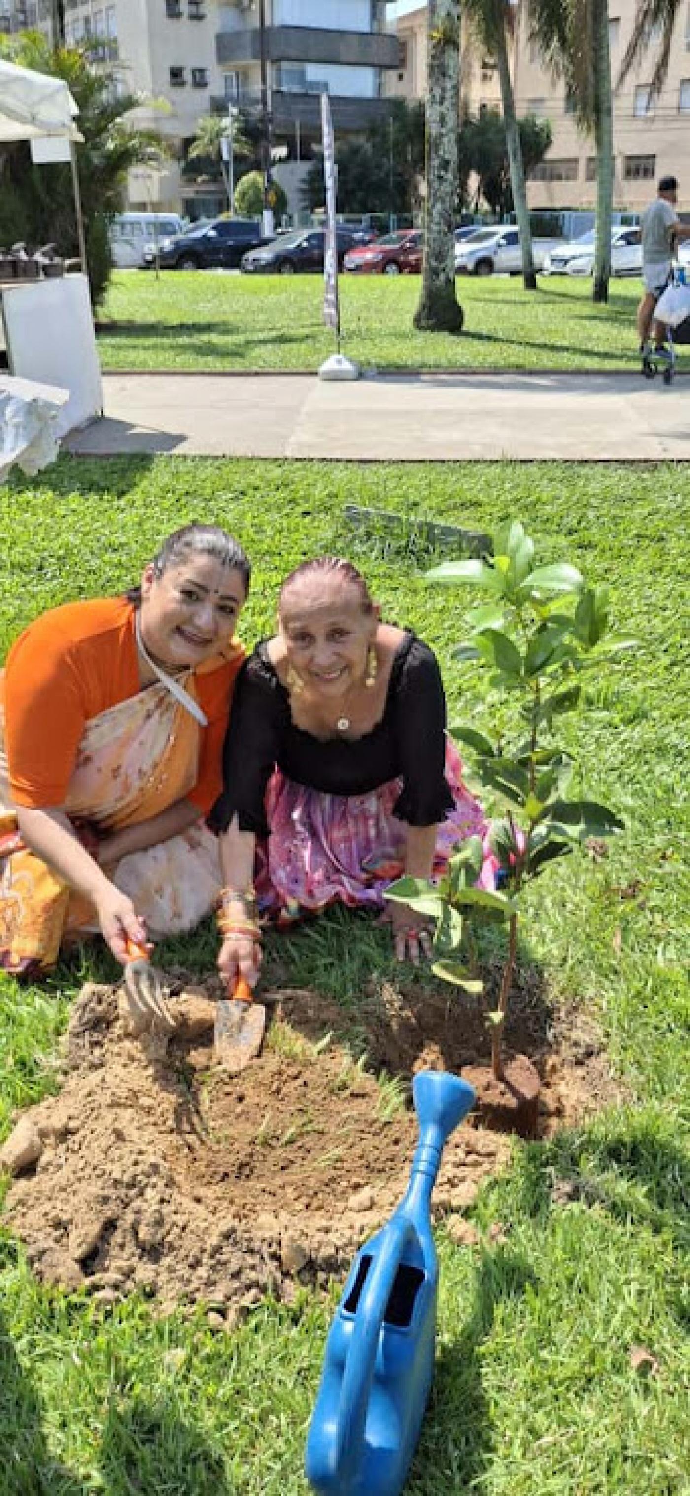 duas mulheres plantam árvore #paratodosverem