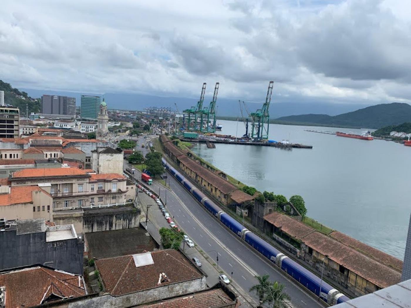 vista geral de área do porto na região do Valongo. Os antigos armazéns estão na frente do mar. ao fundo, guindastes. Do lado esquerdo, edificações da cidade. #paratodosverem