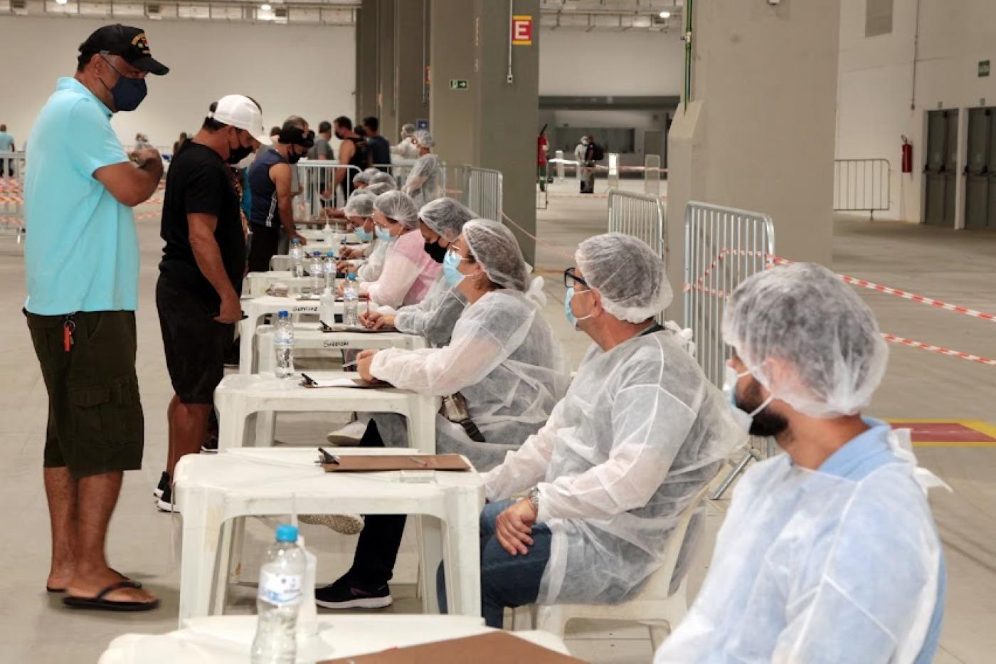 Profissionais fazem as anotações de portuários para vacinação. #paratodosverem