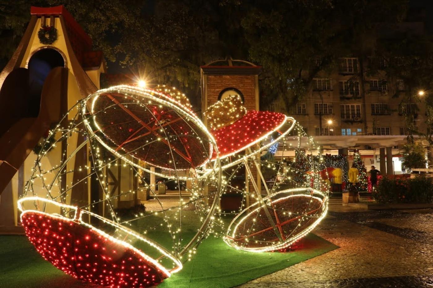 decoração de bolas gigantes e iluminadas na praça mauá. Ao fundo, umas casinhas imitando uma vila de natal. #paratodosverem