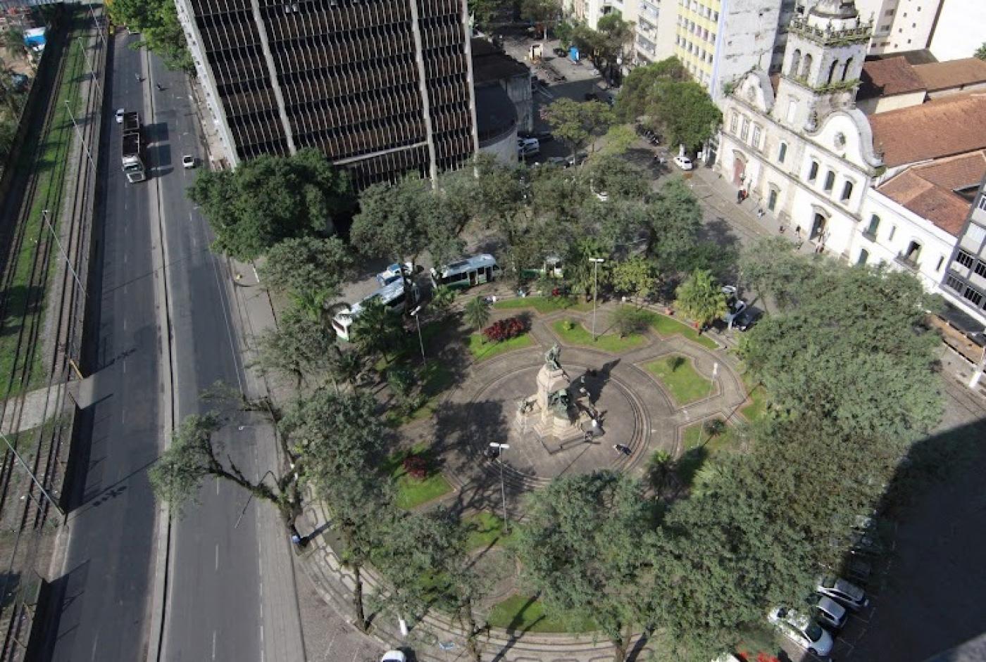 vista aérea da praça, com monumento ao centro e o pantheon e conjunto religioso ao fundo. #paratodosverem