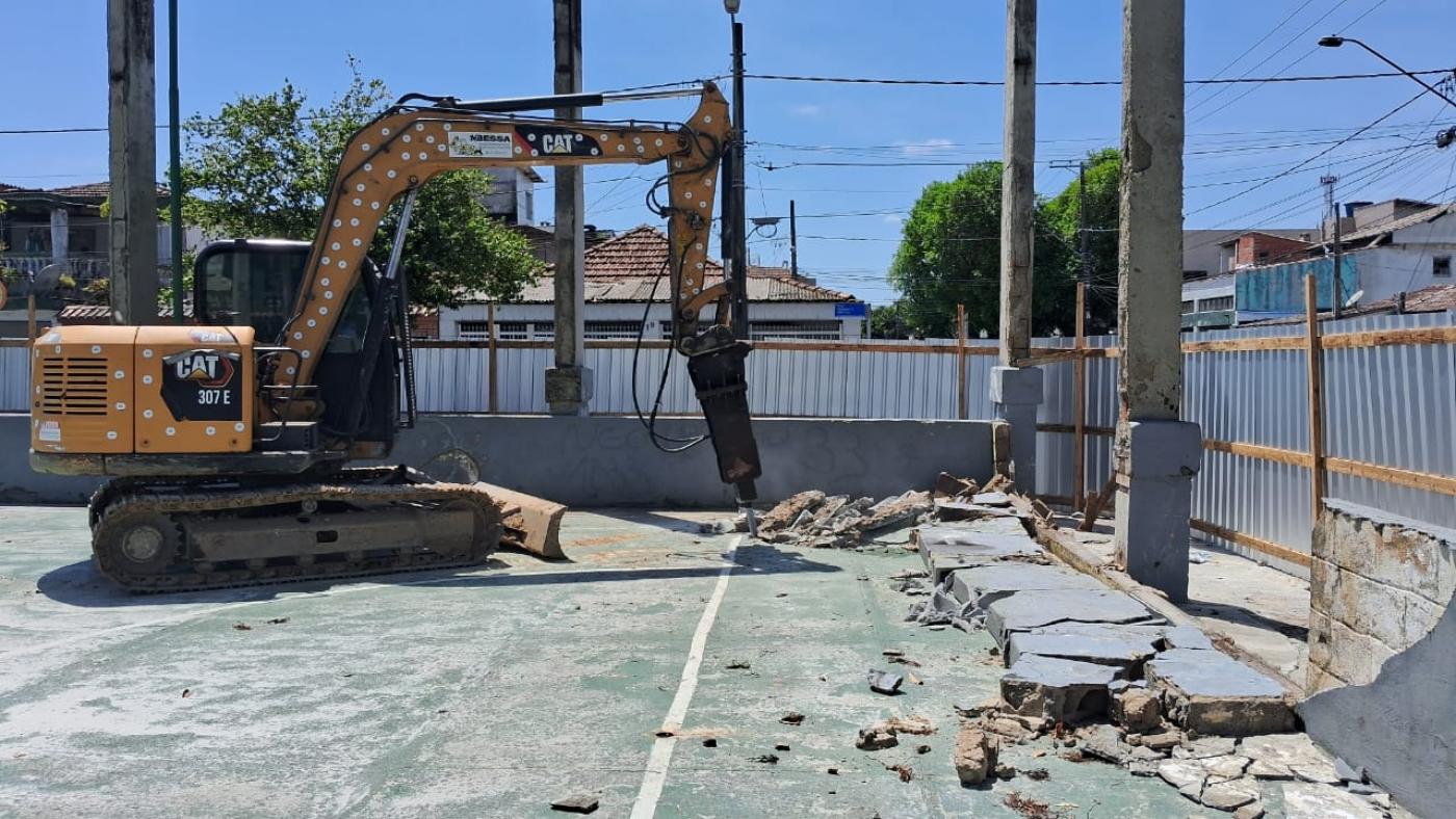 escavadeira quebra piso antigo Ela está dentro de área tapumada