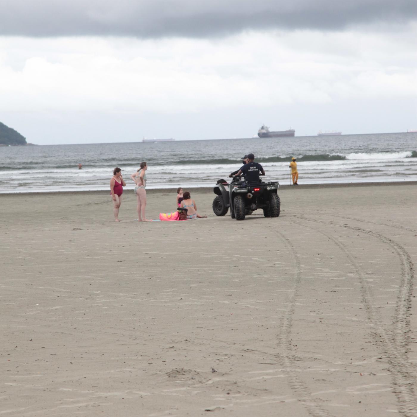 Guardas municipais abordam banhistas em faixa de areia. #paratodosverem