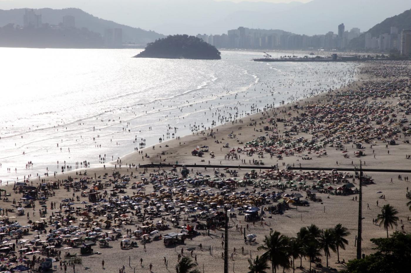 turistas na praia em visão aérea #paratodosverem 