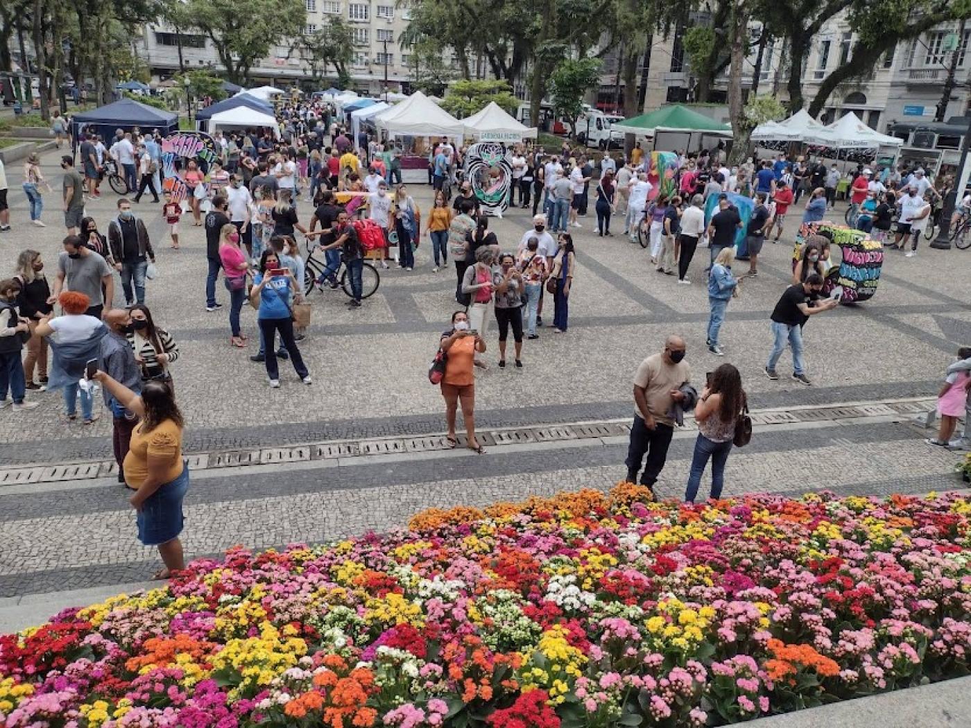 Várias pessoas na praça e muitas flores #paratodosverem