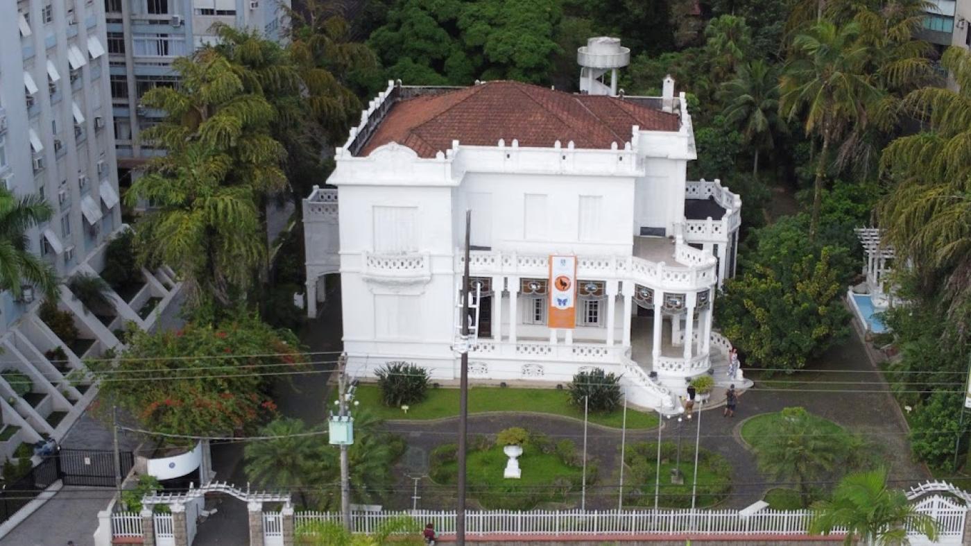 casarão branco cercado por verde #paratodosverem