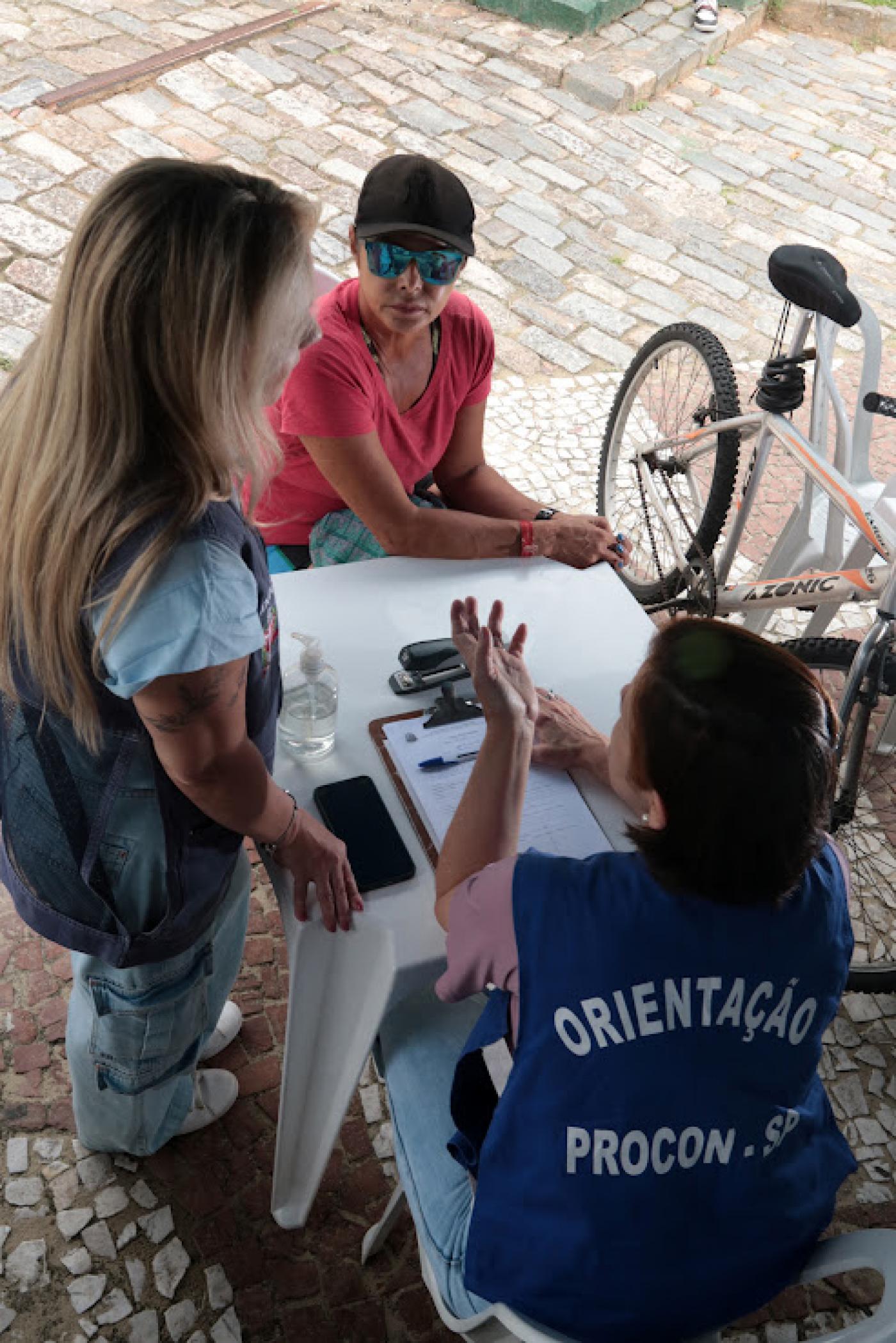 pessoas sendo atendidas no procon móvel #paratodosverem 