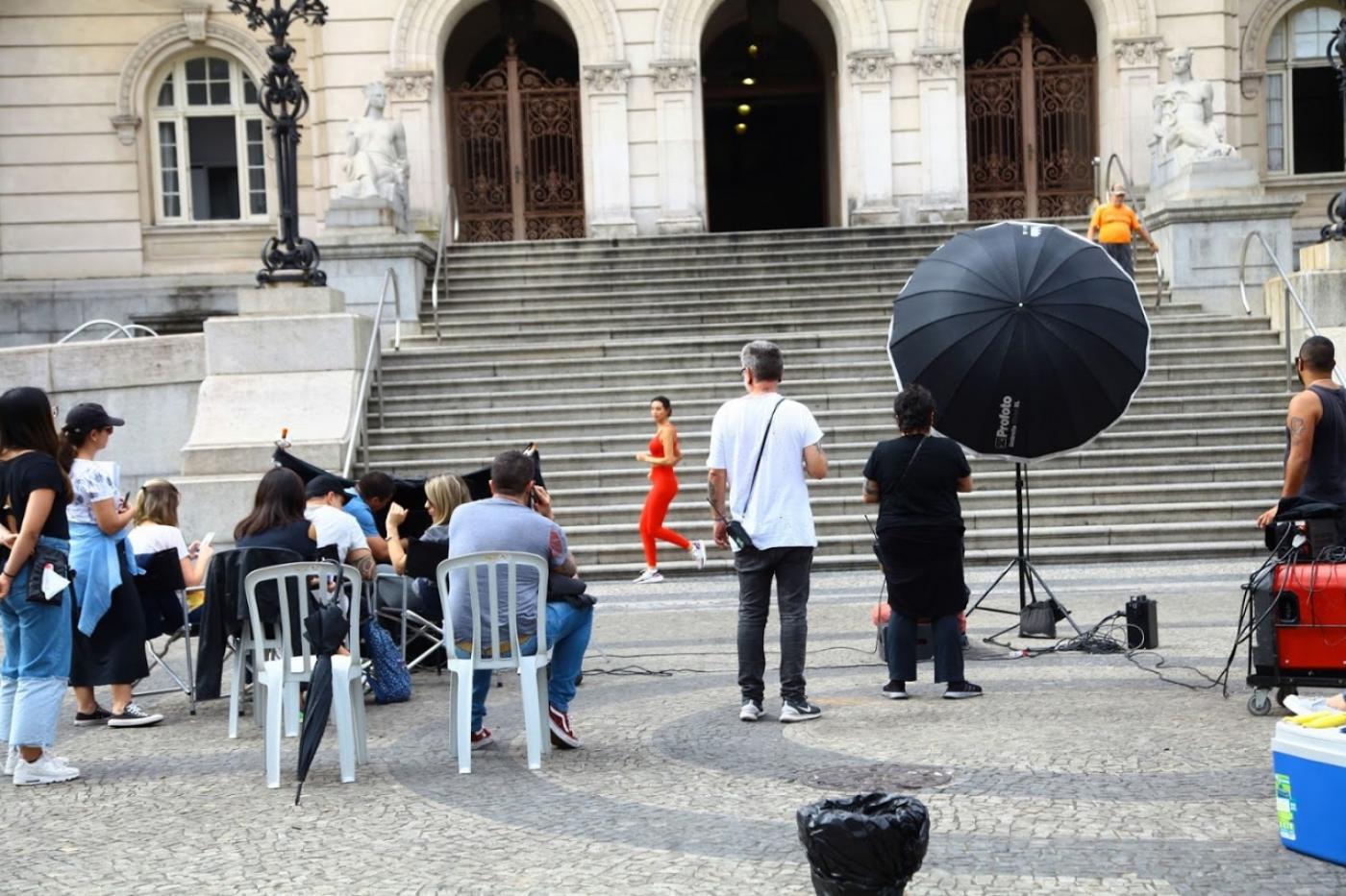 Equipe de filmagem, com equipamentos filma cena diante da escadaria de acesso à prefeitura, na praça mauá. #paratodosverem