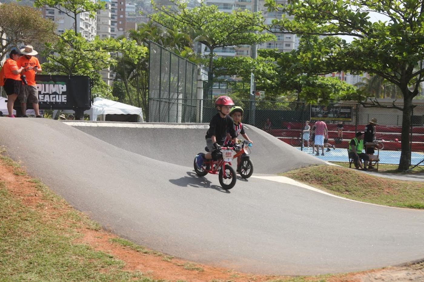 crianças de bicicleta em pista de pump track #paratodosverem