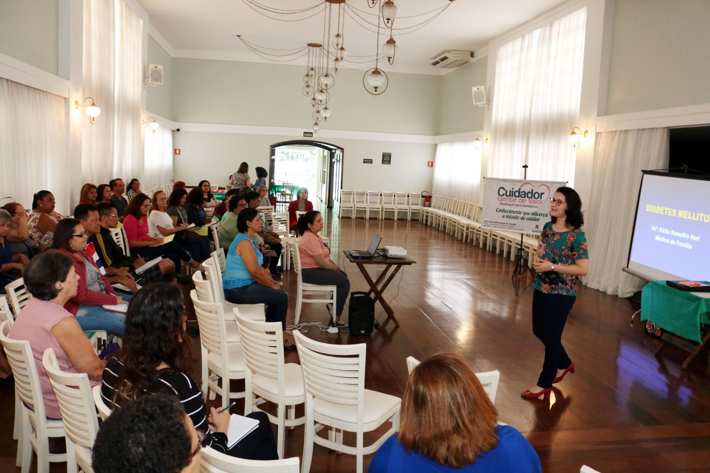 professora fala enquanto alunos do curso acompanham sentados #pracegover 