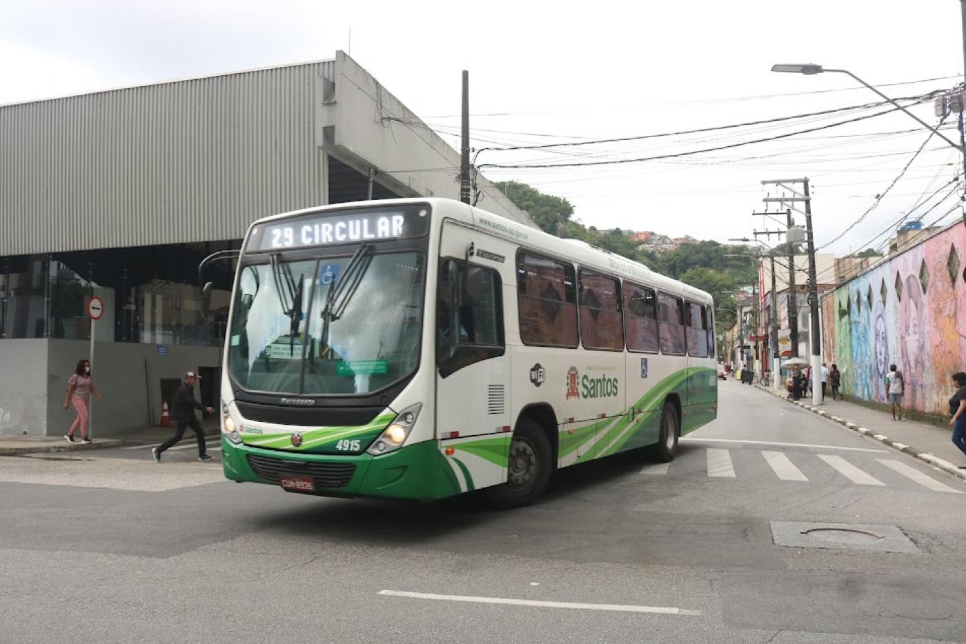 ônibus na rua fazendo curva em esquina. #paratodosverem